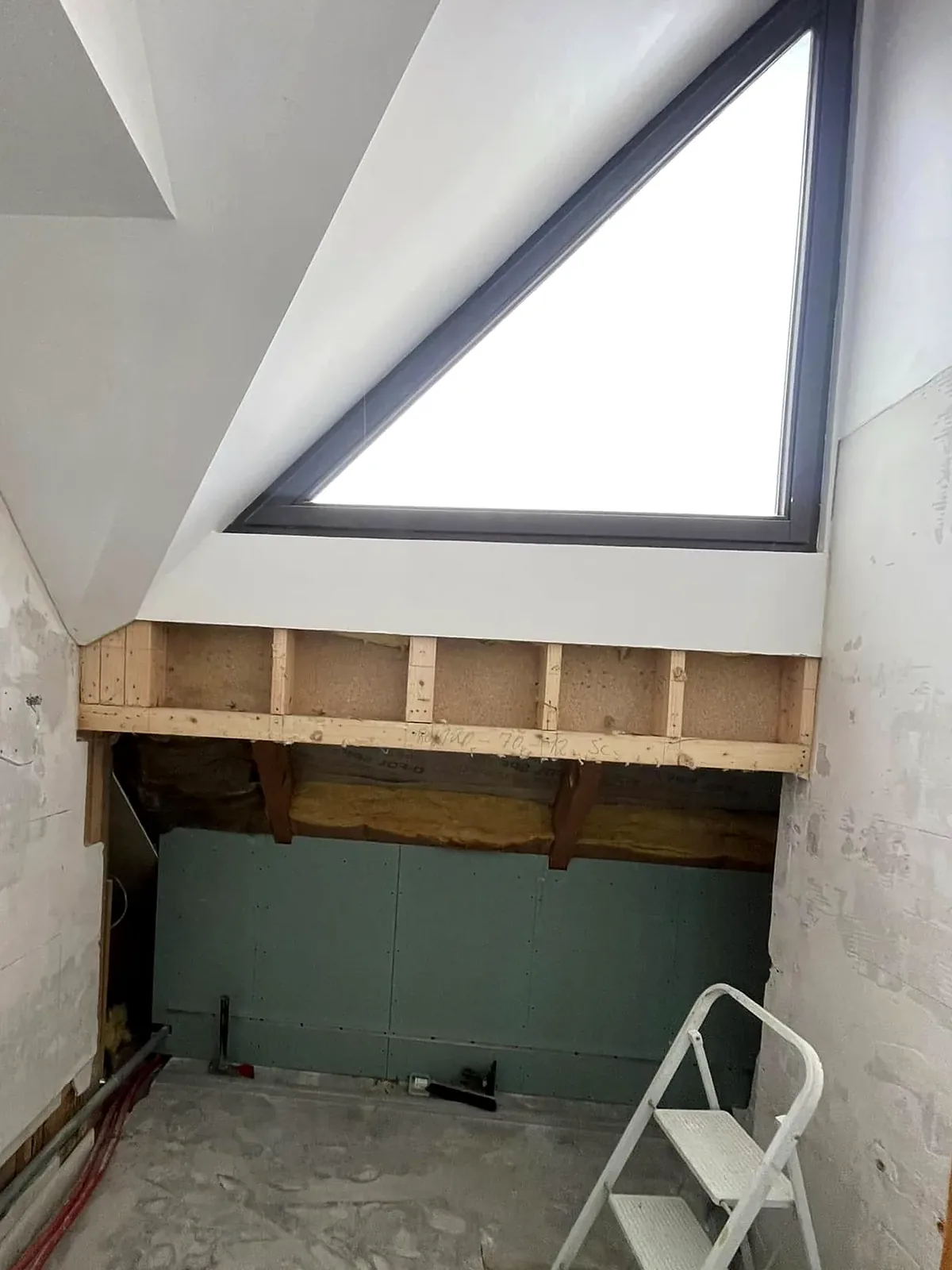 Avant travaux : ossature bois et plaques hydrofuges sous la fenêtre triangulaire