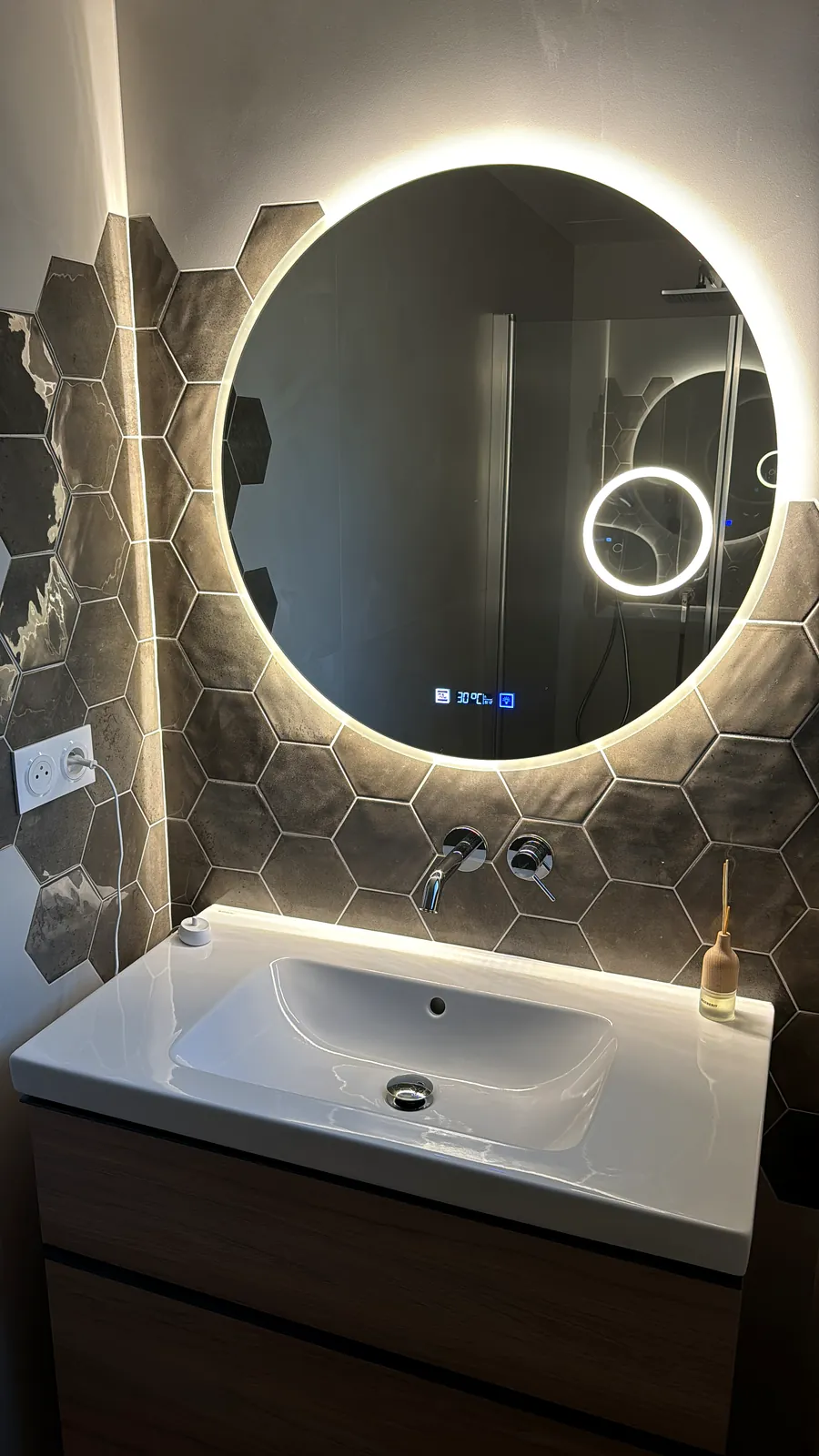 Meuble vasque, miroir rond rétroéclairé et carrelage hexagonal