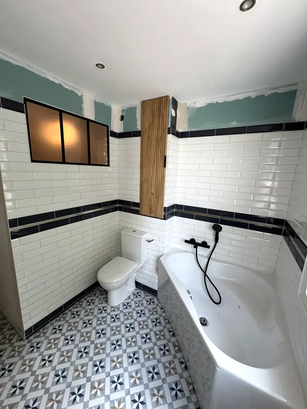 Salle de bains faïence métro à frise bleu nuit, baignoire et verrière
