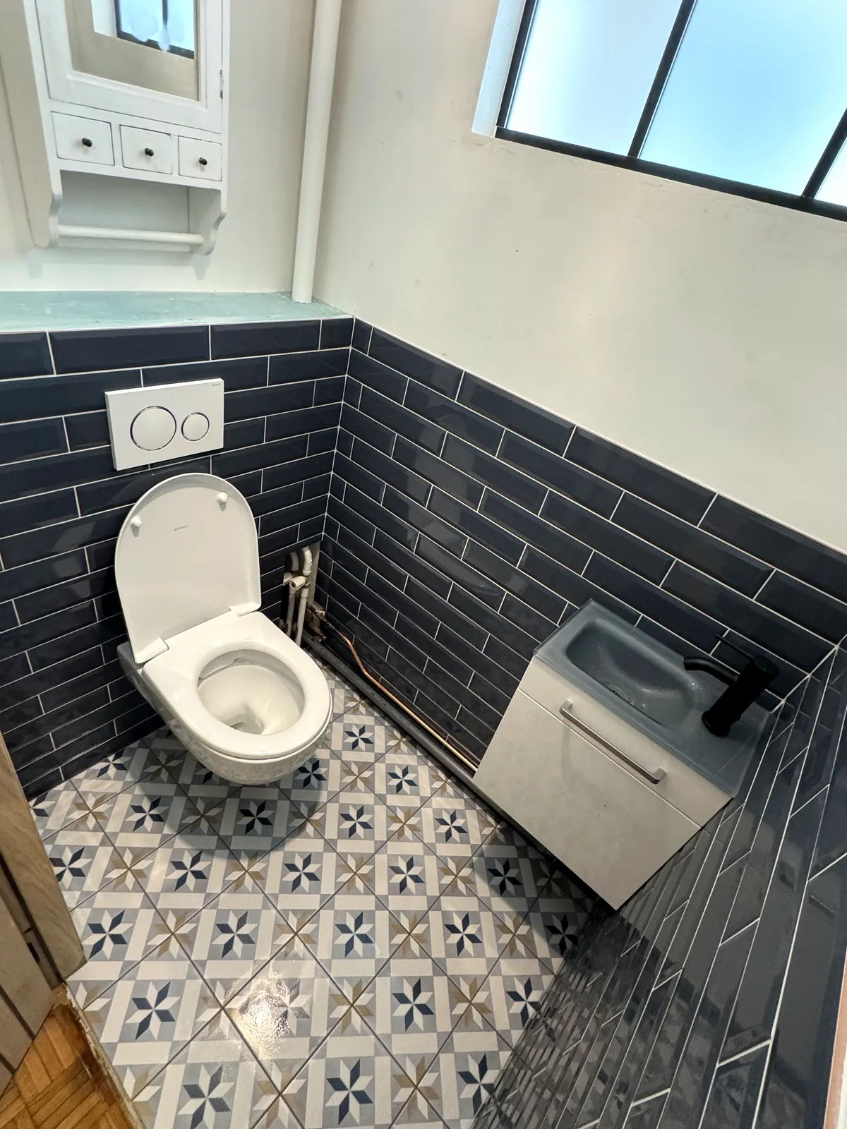 WC suspendu et lave-mains sur carreaux de ciment