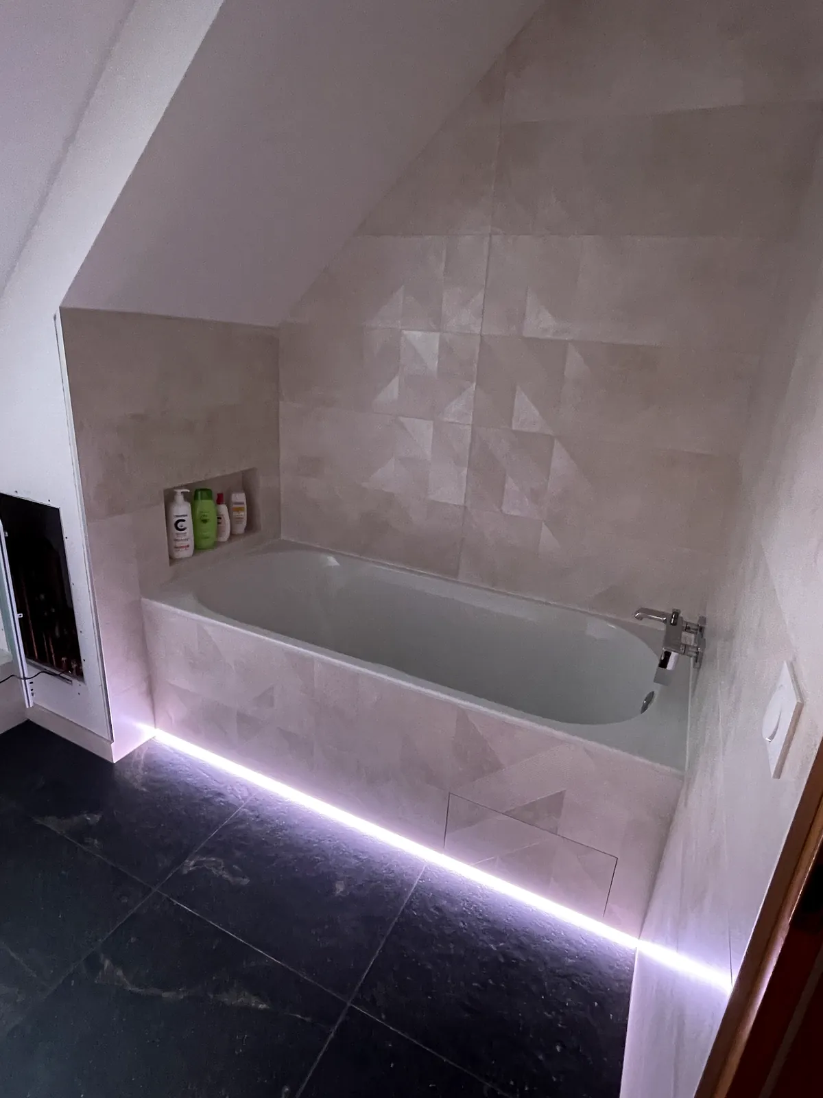 Baignoire encastrée sous la pente, niche et bandeau LED en plinthe