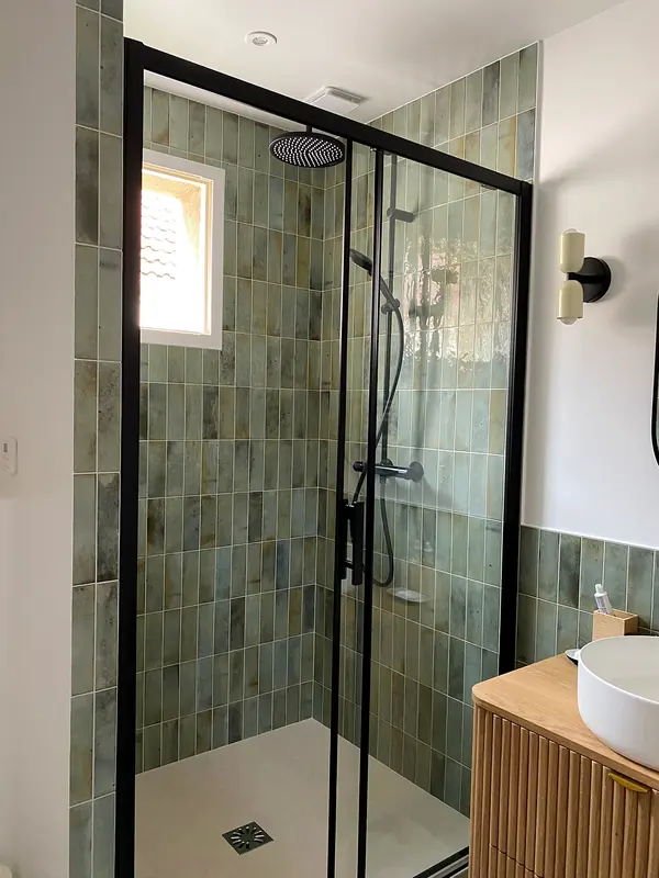 Douche en zellige vert d'eau avec paroi à profilés noirs